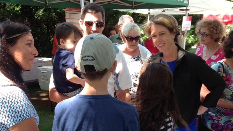 Zephyr Teachout (Right) discusses a range of topics with visitors to Southampton Farmers' Market on Aug. 24, 2014. (Jaime Franchi/Long Island Press)
