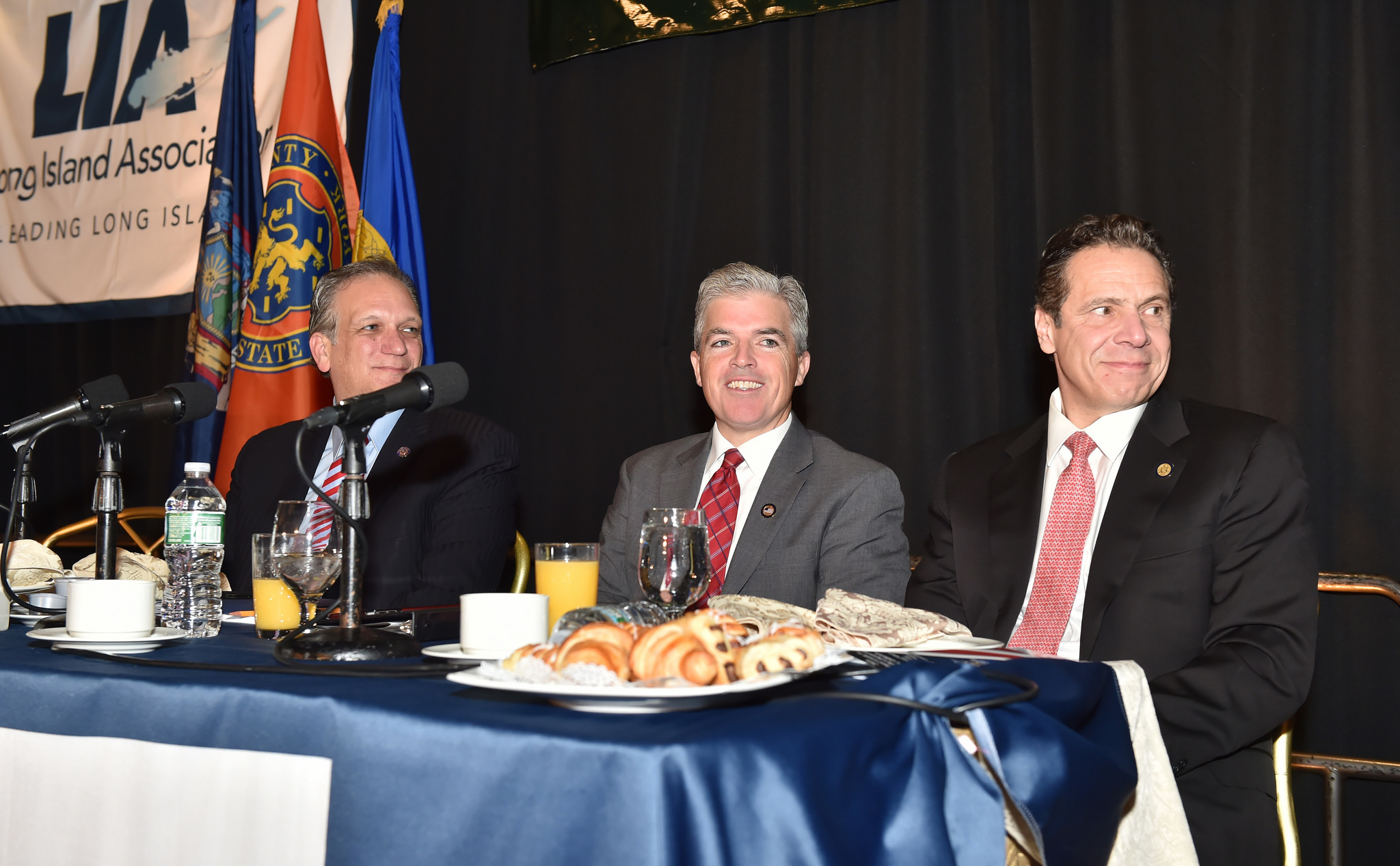 Nassau County Executive Ed Mangano (left) and his counterpart in Suffolk, Steve Bellone (center), join Gov. Andrew Cuomo at a breakfast unveiling the governor's 2016 agenda. (Photo credit: Kevin P. Coughlin/Office of the Governor)