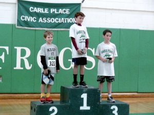 Winner of the fifth and sixth grade boys’ division Jack Hommel, stands atop the podium. He is flanked by second place winner Aiden Reid and third place recipient Philip Alfieri.