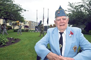 Catholic War Veterans member Pete Johnson of Hicksville served with the U.S. Navy from 1948-52, spending time on the destroyer Myles C. Fox (“[Serial number] DDR-829,” he quickly added). Behind him, members of the U.S. Army 333rd Military Police Brigade carry the wreaths from the Veterans Memorial Park to the post-parade ceremony. (Photo by Frank Rizzo)