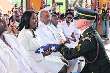 Cheryl Wills receives Sandy Wills’ veteran flag at her great-great-great grandfather's recommittal ceremony.