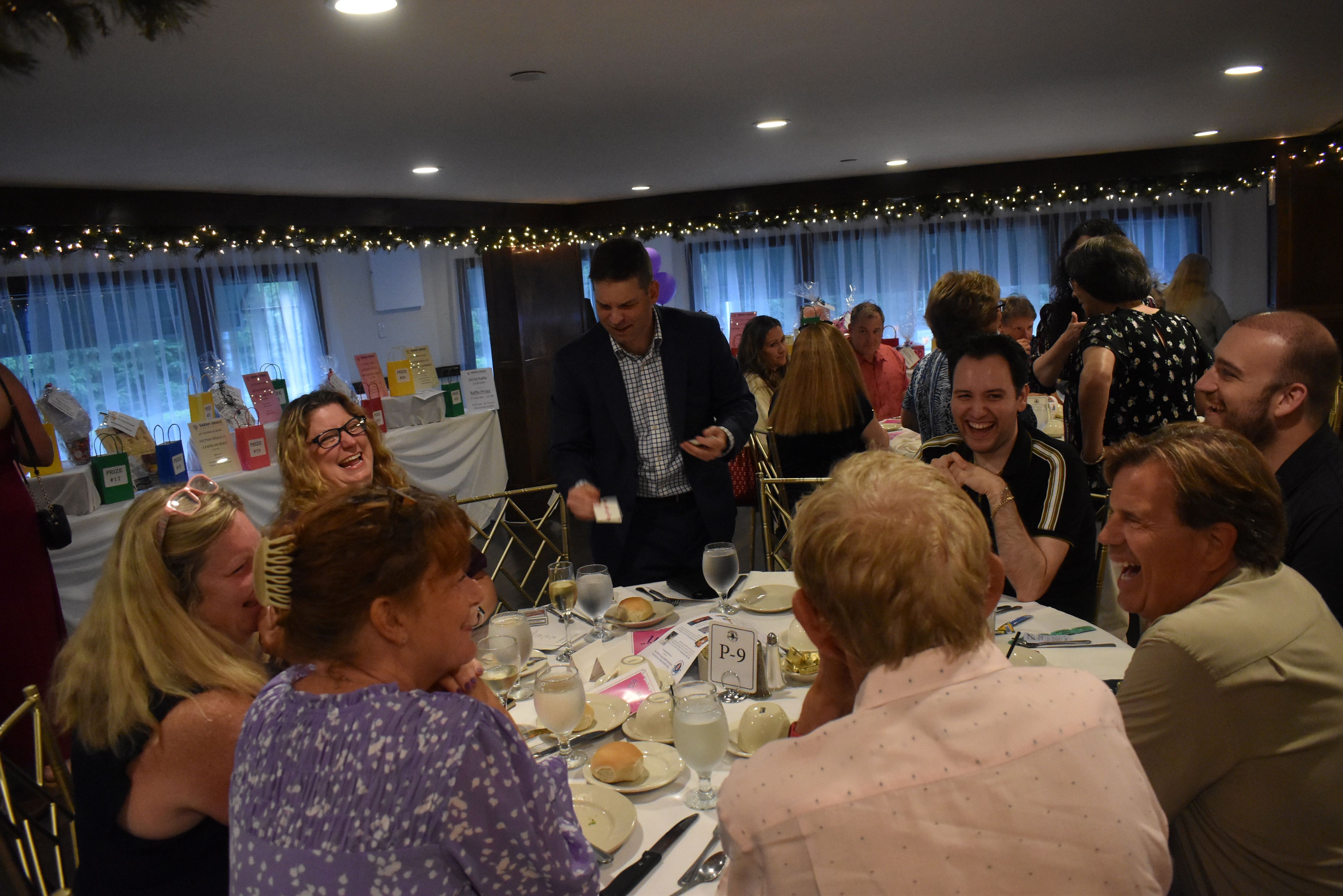 Attendees watch a magic trick at the 2024 An Evening of Magic