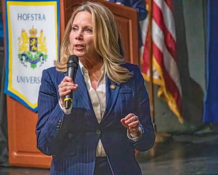 U.S. Rep. Laura Gillen standing, speaking into microphone. 