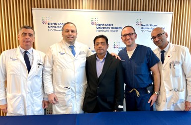 Northwell surgeons stand with Sergio Cestoni in the middle at a press conference after his surgery.
