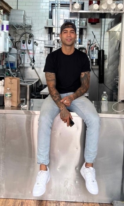 Kevin Resvani, the founder of 7th Street Burger, sitting in on the counter of one of his restaurants. 