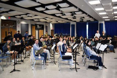 Manhasset High School Symphonic Wind Ensemble and Director of Bands Gregory Sisco with composer Jessica Meyer as they prepare to rehearse Meyer’s composition "From City to Shore.”