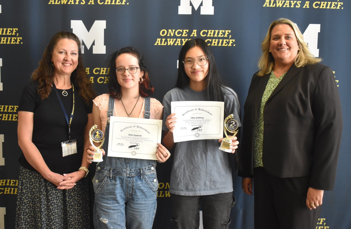 Spanish teacher Pamela Schellberg, left, and Massapequa High School Principal Barbara Lowell congratulated Silvia Izquierdo and Chloe Goldberg on their awards in the Long Island Language Teachers student language competition.