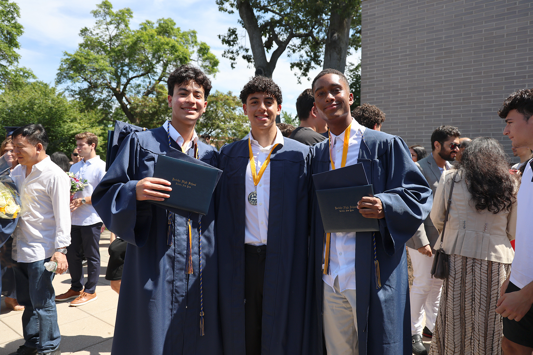 Graduates hold up their diplomas, marking the end of their high school careers