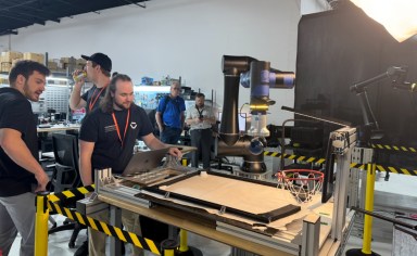 Standard Bots employees demonstrate how to pick up items with the company's automation technology.