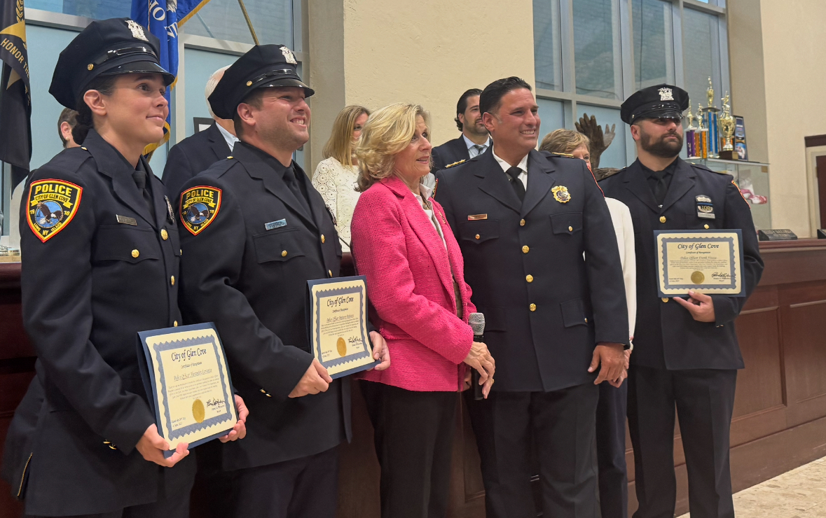 Mayor Pam Panzenbeck (Center L.) and Deputy Chief Chris Ortiz (Center R.) recognize three police officers who had gone into the building during the Glen Cove Avenue apartment fire in April, at meeting where council amends noise ordinance.