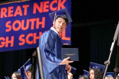 A Great Neck South High School senior walks across the stage after receiving his diploma.