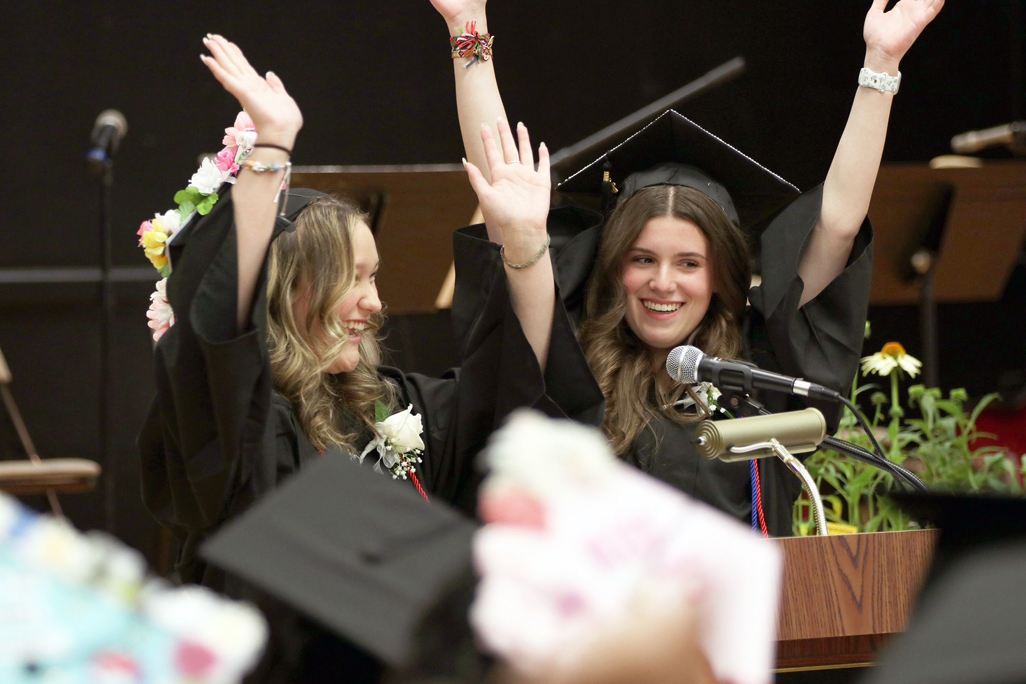 Two students speak at the podium at the Village School graduation.
