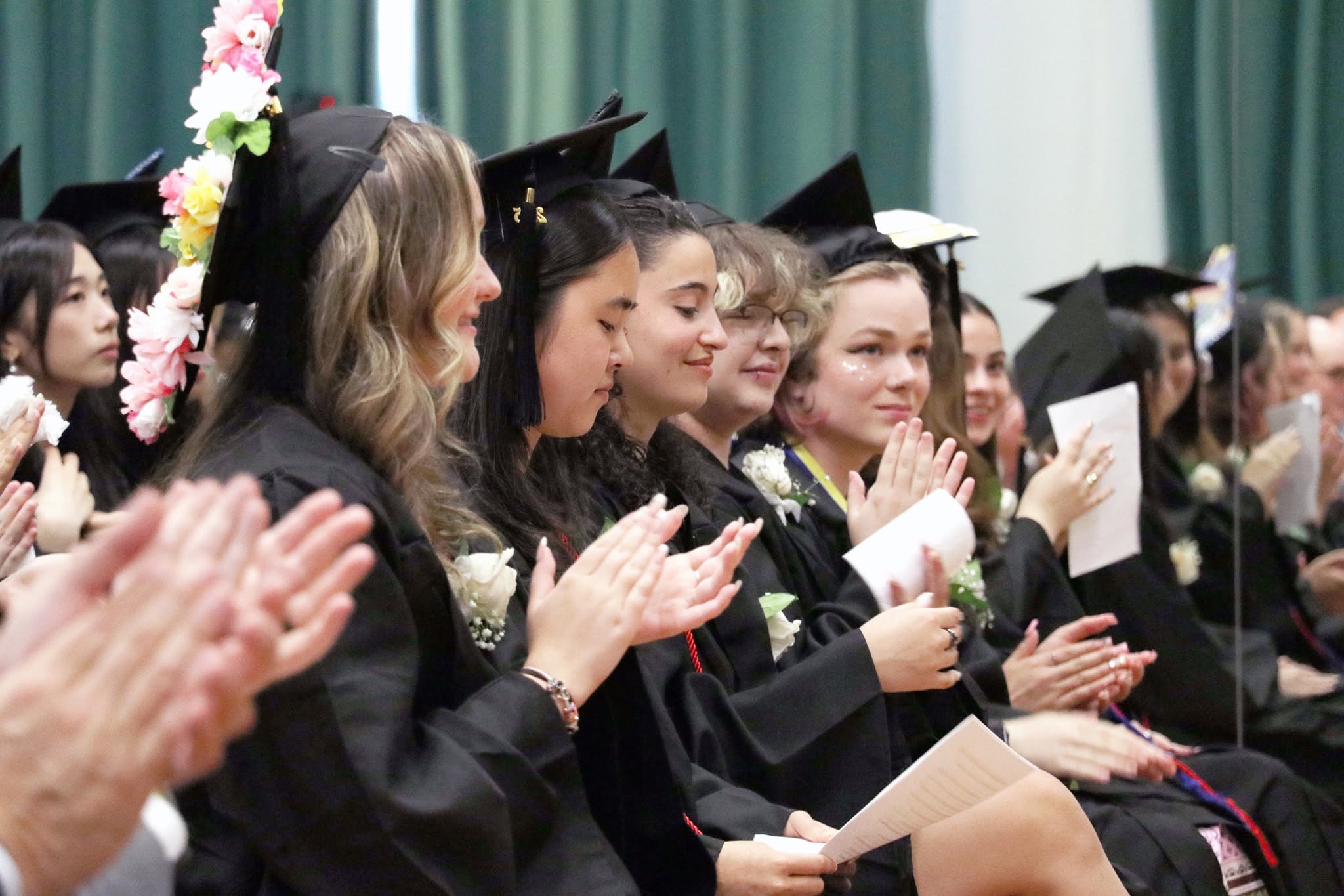 Graduating seniors cheer and clap.