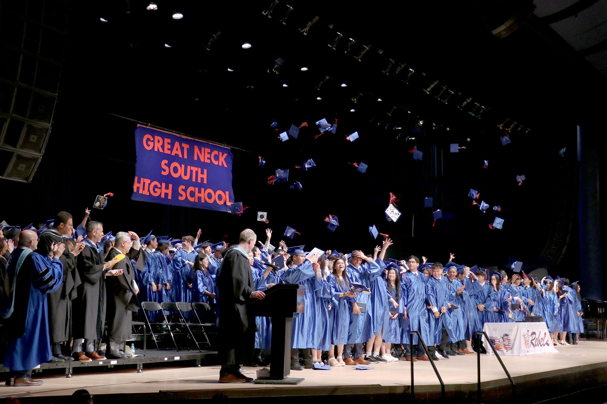 Great Neck South High School seniors throw their caps into the air.