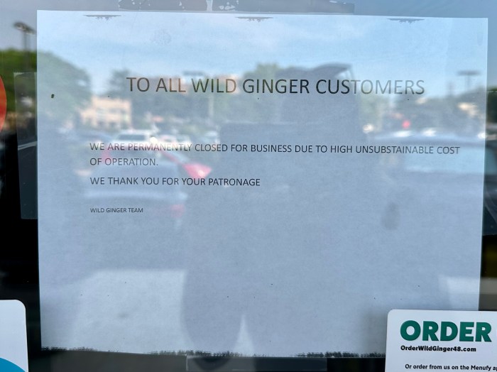 A sign in the window of Wild Ginger states the restaurant closed due to high costs.