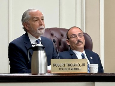 North Hempstead Town Council Member Robert Troiano (L.) proposed that an amendment be made in the future to provide greater relief to innocent homeowners affected by the building department's corruption.