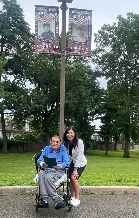 Gerald Schiraldi and Christine Liu underneath the veteran's banner.