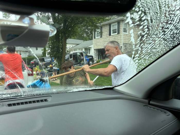 Community working together to clean cars for a fundraiser in Port Washington.