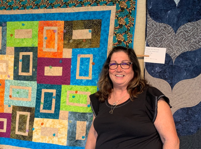 Patti Schust stands in front of one of her designs at a previous exhibition.